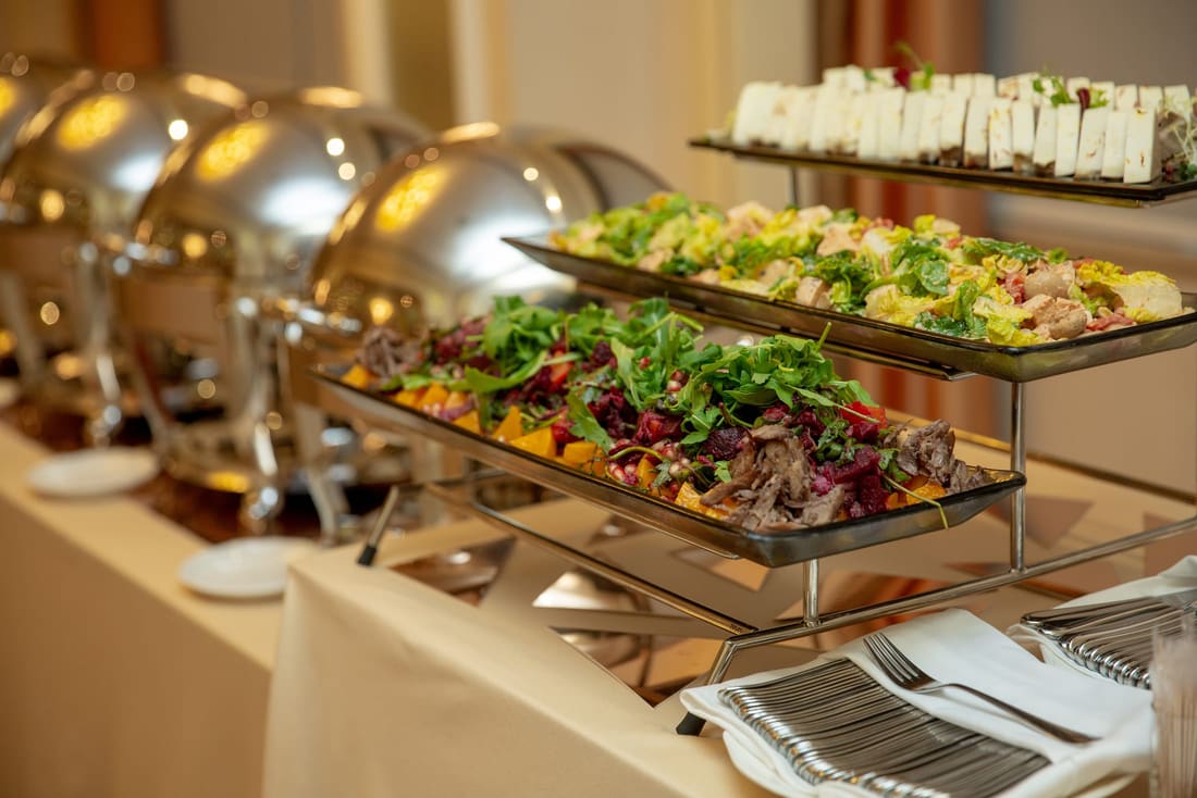Buffet line with chafing dishes and fresh salads